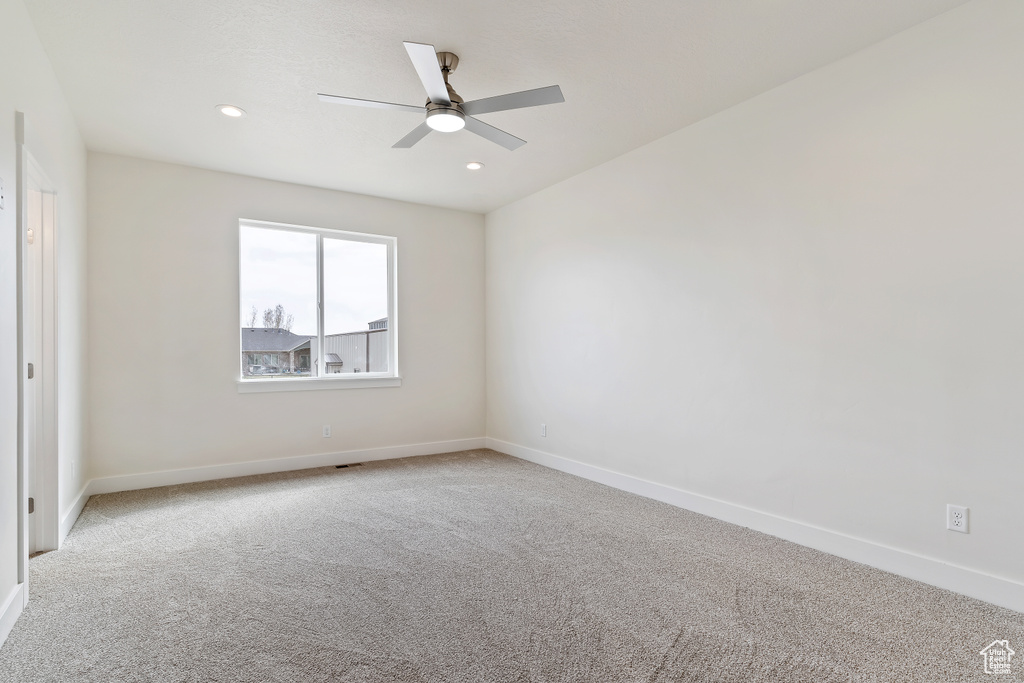 Unfurnished room featuring ceiling fan and light carpet