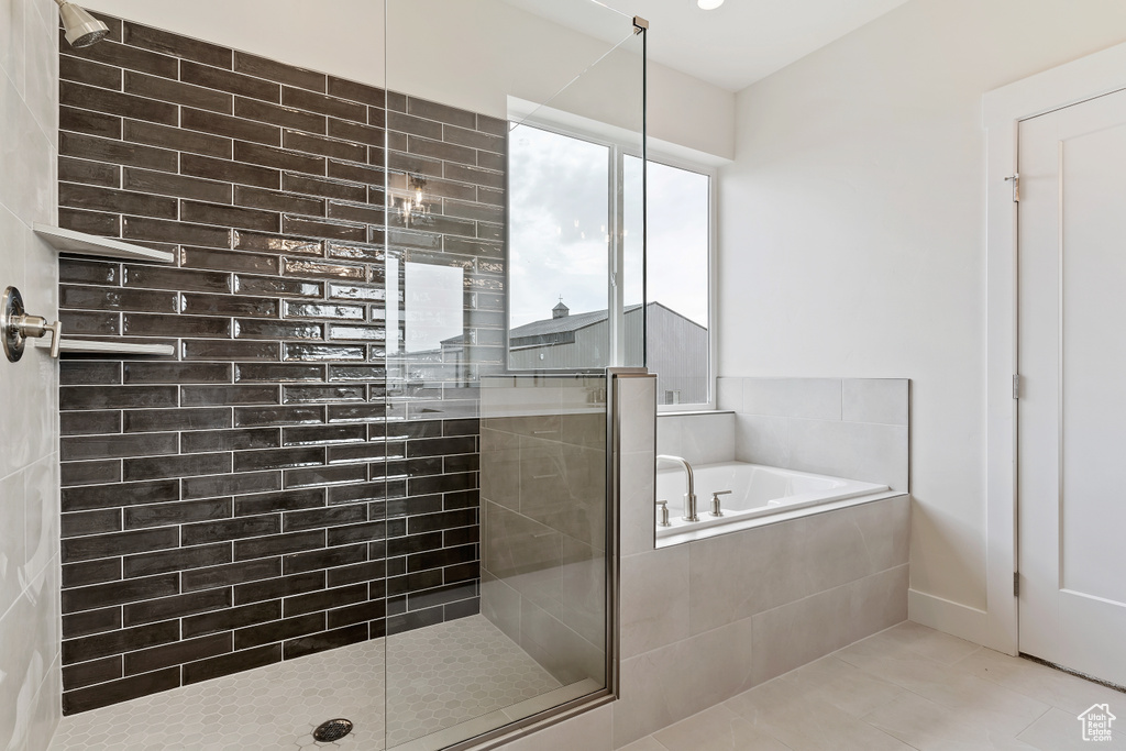 Bathroom featuring shower with separate bathtub and tile patterned floors