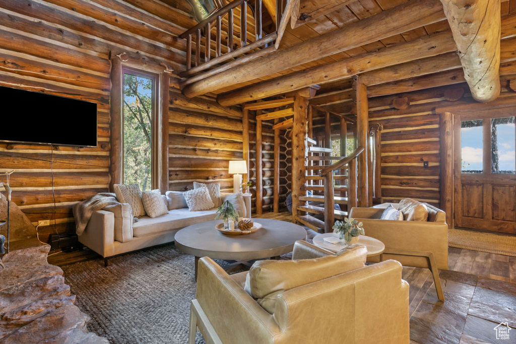 Living room featuring log walls and wood ceiling