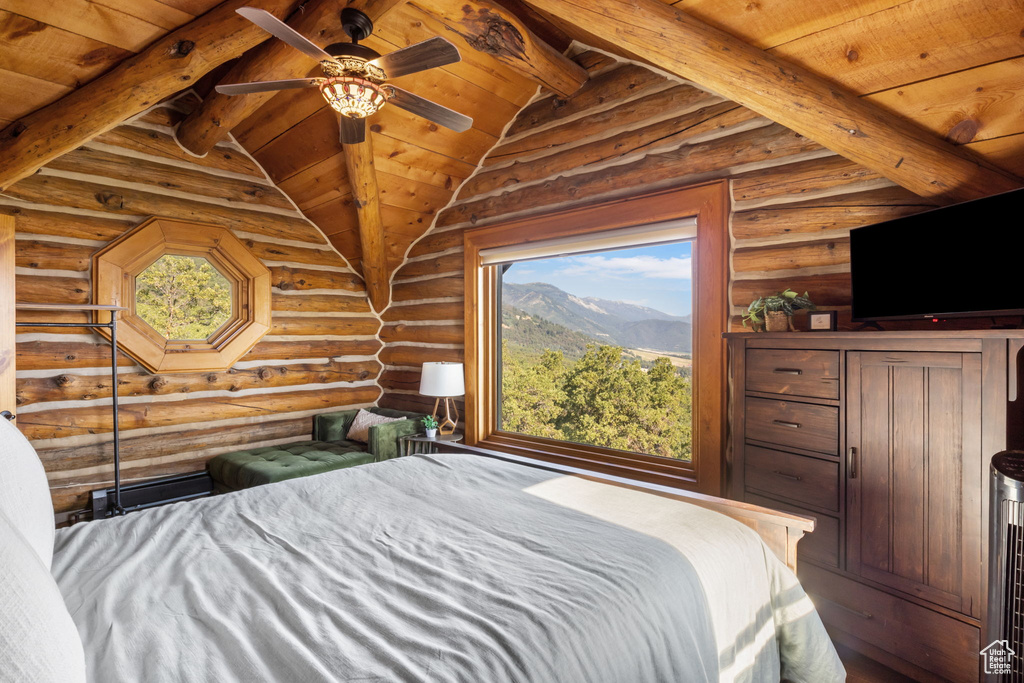 Bedroom featuring multiple windows, wood ceiling, lofted ceiling with beams, and log walls