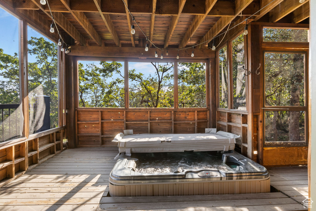 Unfurnished sunroom featuring a hot tub