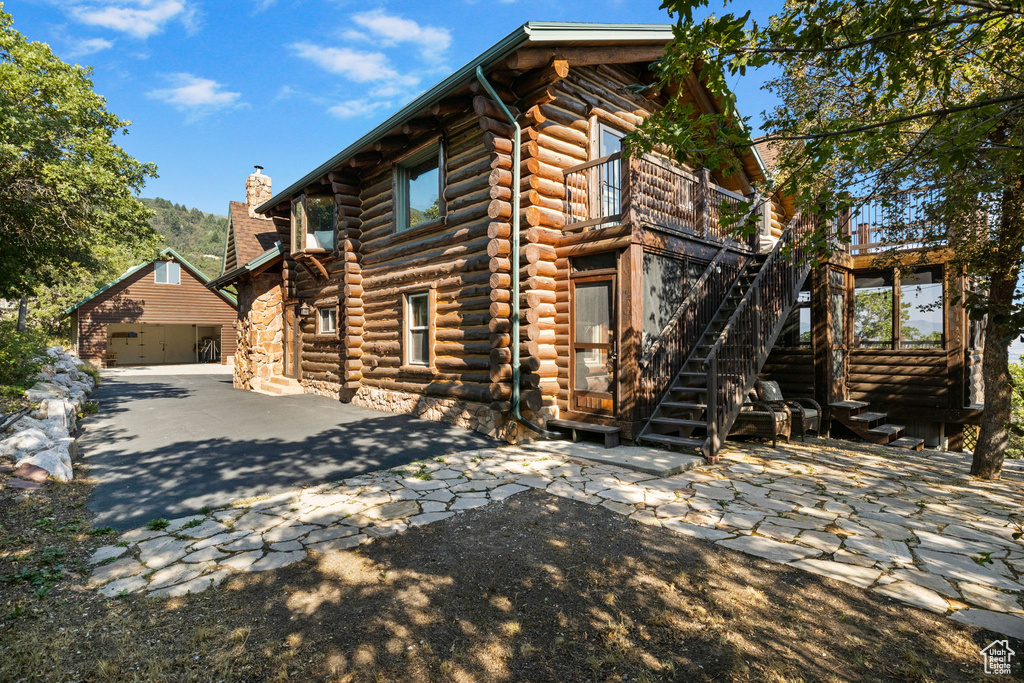 Rear view of property featuring a garage and an outbuilding