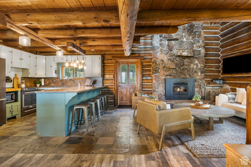 Kitchen with log walls, plenty of natural light, and wooden ceiling