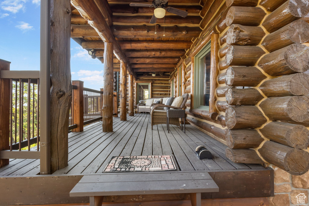 Wooden deck featuring outdoor lounge area and ceiling fan