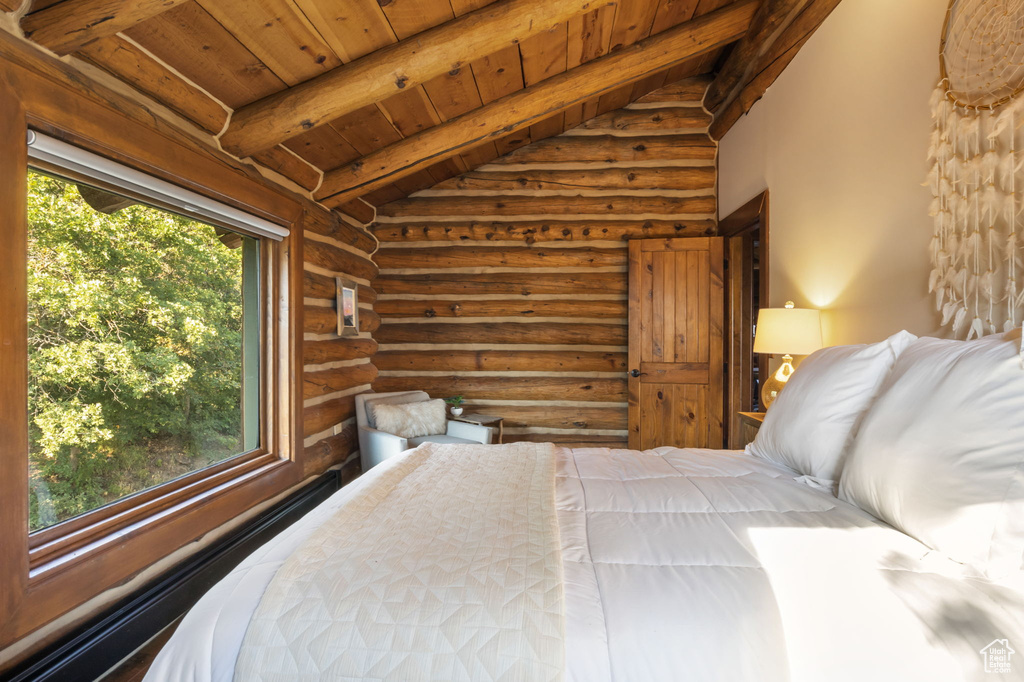 Bedroom featuring lofted ceiling, rustic walls, multiple windows, and wood ceiling