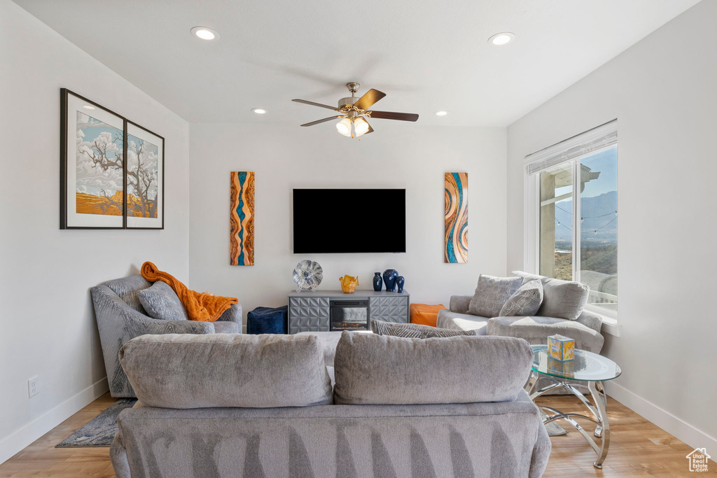 Living room featuring ceiling fan and light hardwood / wood-style floors