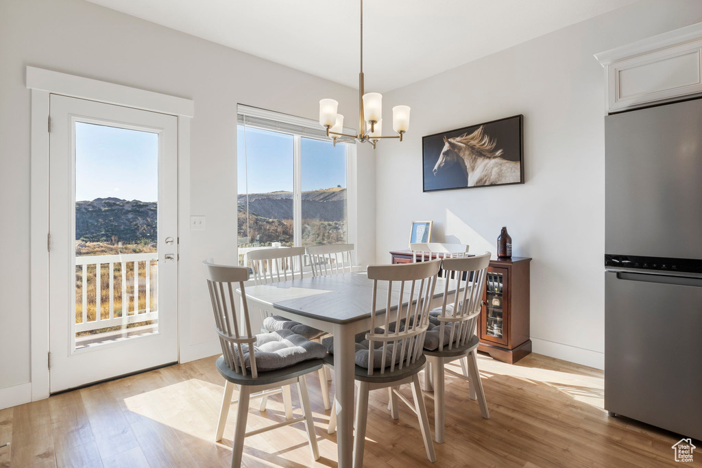 Dining room featuring a mountain view, light hardwood / wood-style floors, and a notable chandelier