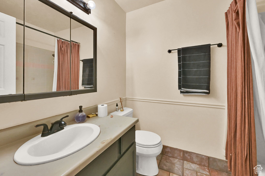 Bathroom featuring vanity, toilet, and a shower with shower curtain