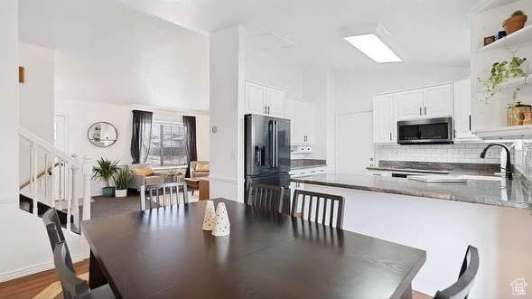 Dining room featuring lofted ceiling, hardwood / wood-style flooring, and sink