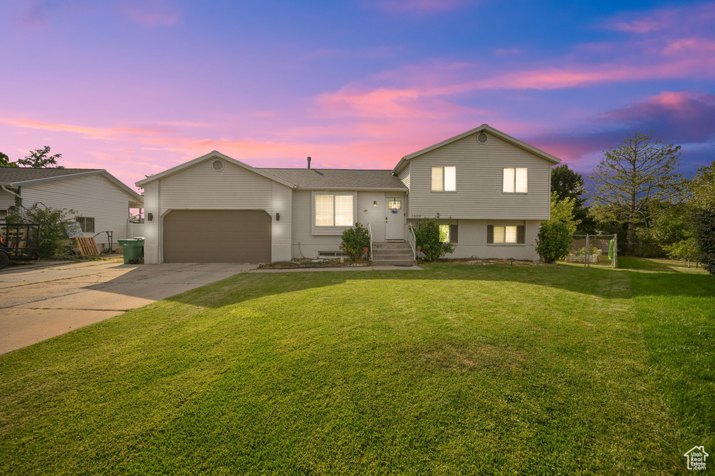 Tri-level home with a lawn and a garage