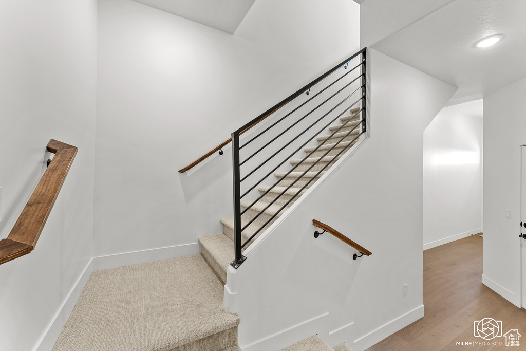 Stairs featuring hardwood / wood-style floors