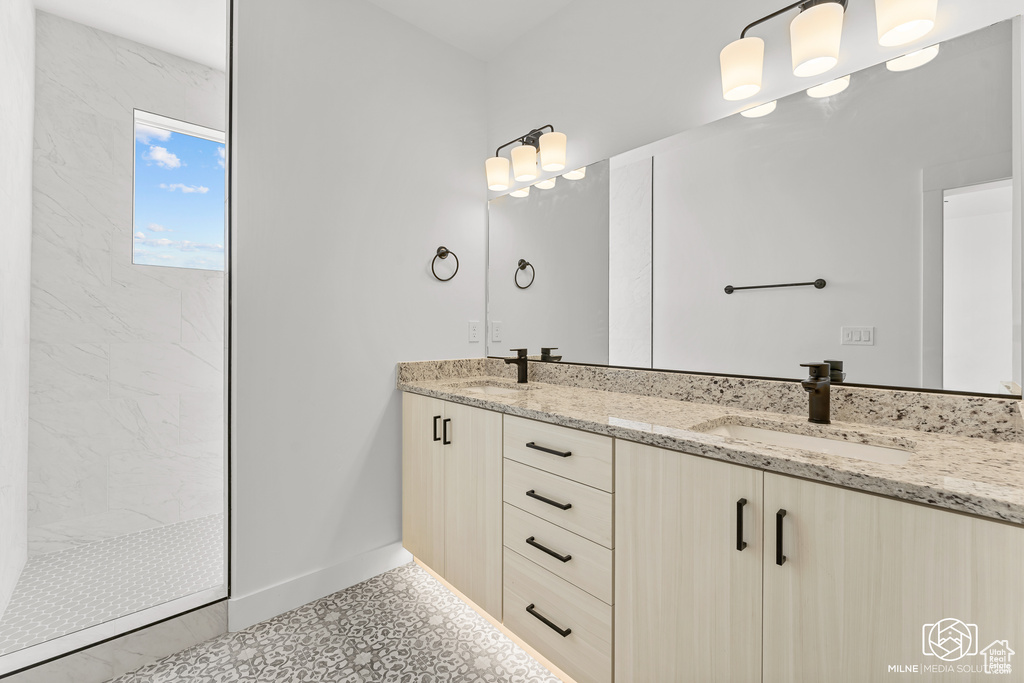 Bathroom with tile patterned flooring, vanity, and tiled shower