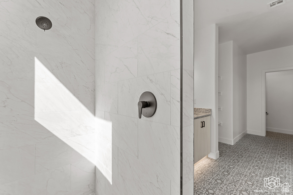 Interior details featuring vanity and tiled shower