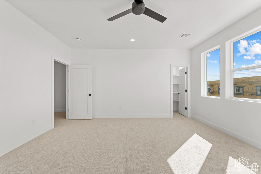 Carpeted spare room featuring ceiling fan