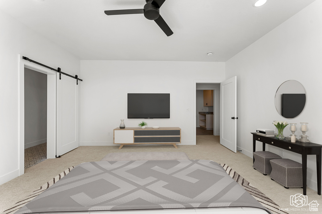 Carpeted bedroom featuring ceiling fan and a barn door