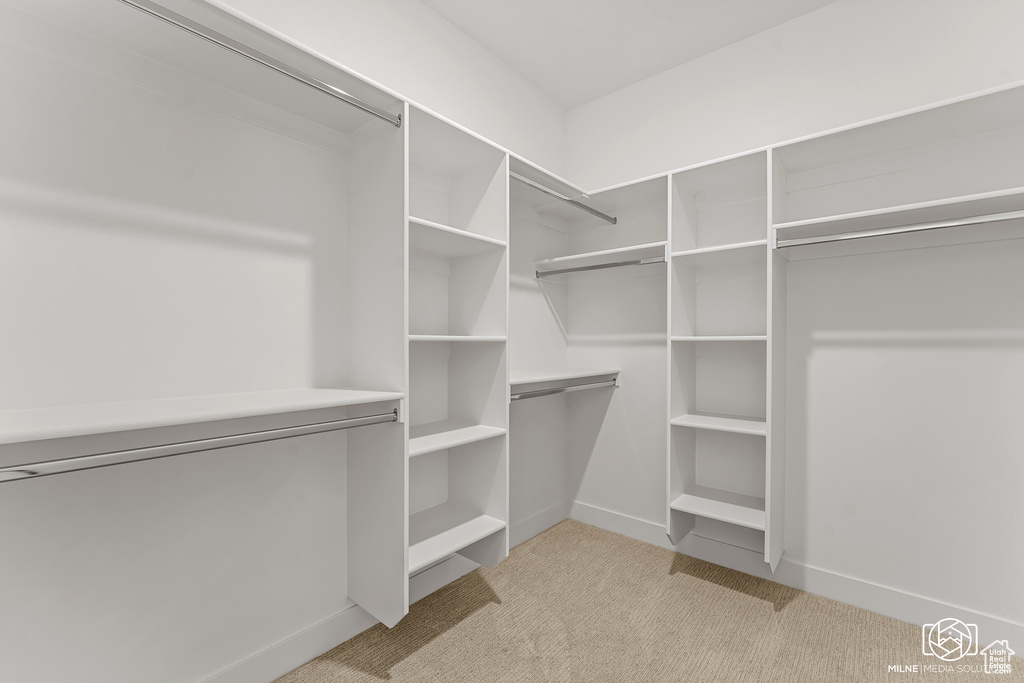 Walk in closet featuring light colored carpet