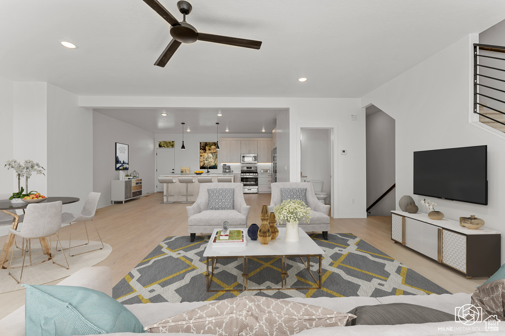 Living room with light hardwood / wood-style flooring and ceiling fan