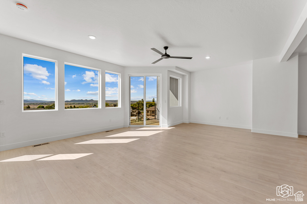 Unfurnished living room with ceiling fan and light hardwood / wood-style floors