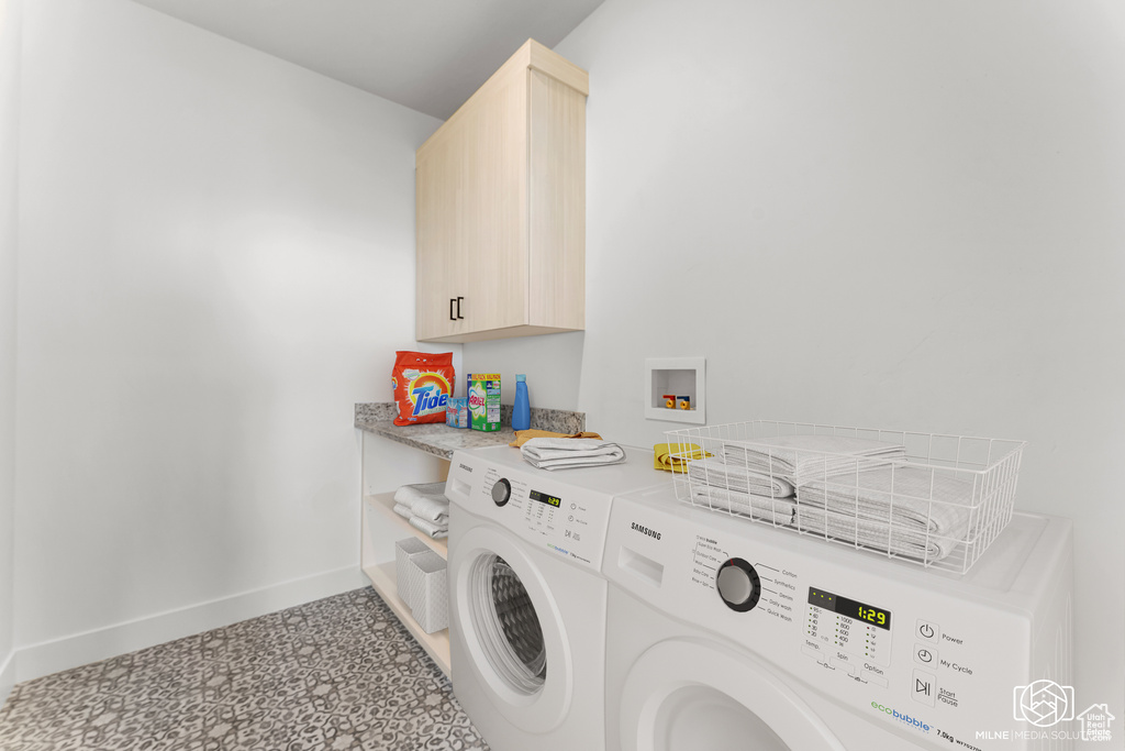 Washroom featuring cabinets and independent washer and dryer