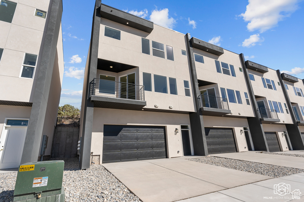 View of front of property with a balcony and a garage