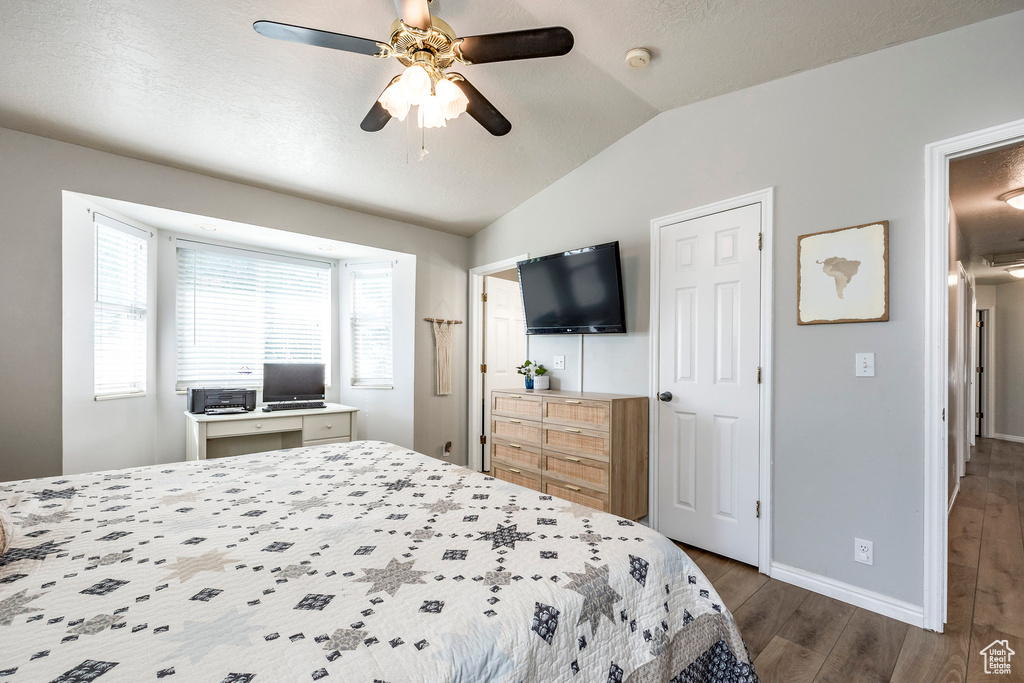 Bedroom featuring vaulted ceiling, dark hardwood / wood-style flooring, and ceiling fan