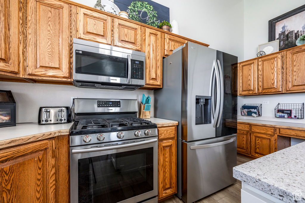 Kitchen with appliances with stainless steel finishes and light hardwood / wood-style floors