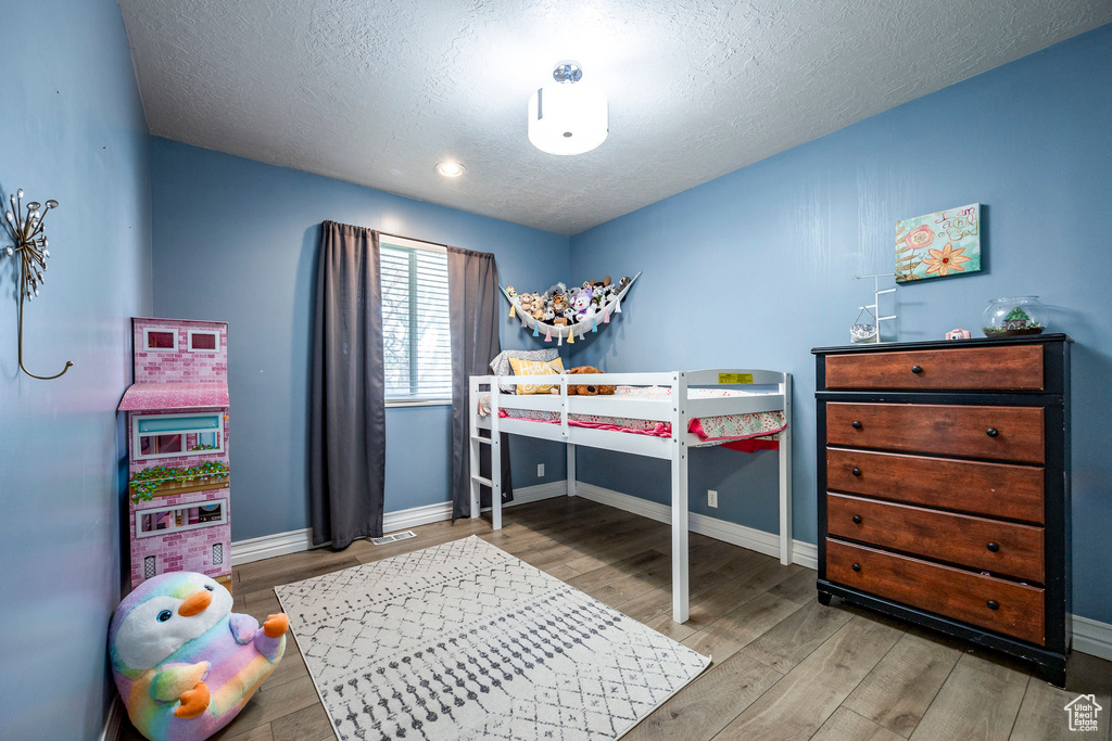 Bedroom with wood-type flooring and a textured ceiling