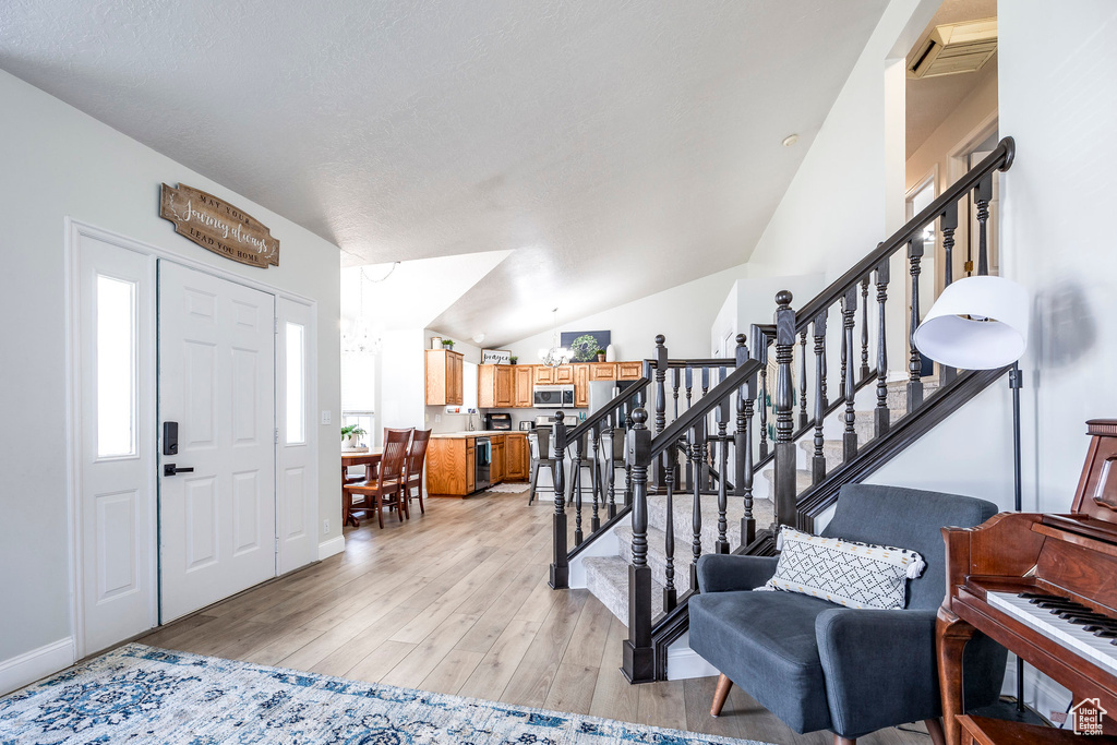 Entryway featuring vaulted ceiling and light wood-type flooring