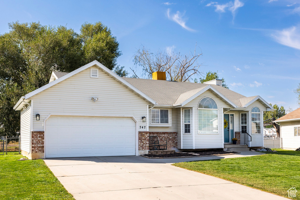 Single story home featuring a front yard and a garage