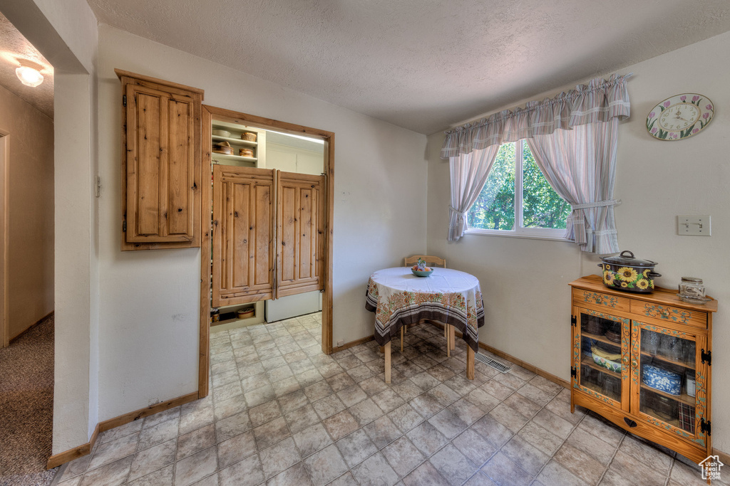 Sitting room with visible vents, baseboards, and a textured ceiling