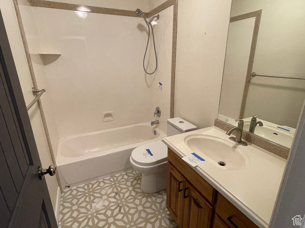 Full bathroom with vanity, toilet, and  shower combination