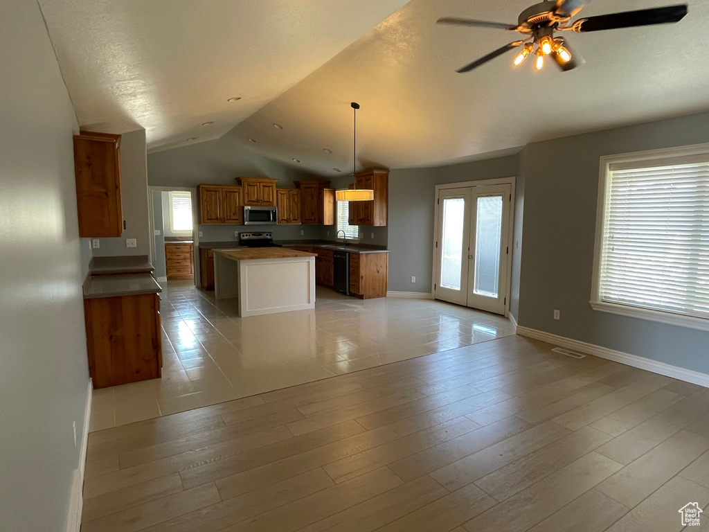 Kitchen with light hardwood / wood-style flooring, ceiling fan, plenty of natural light, and vaulted ceiling