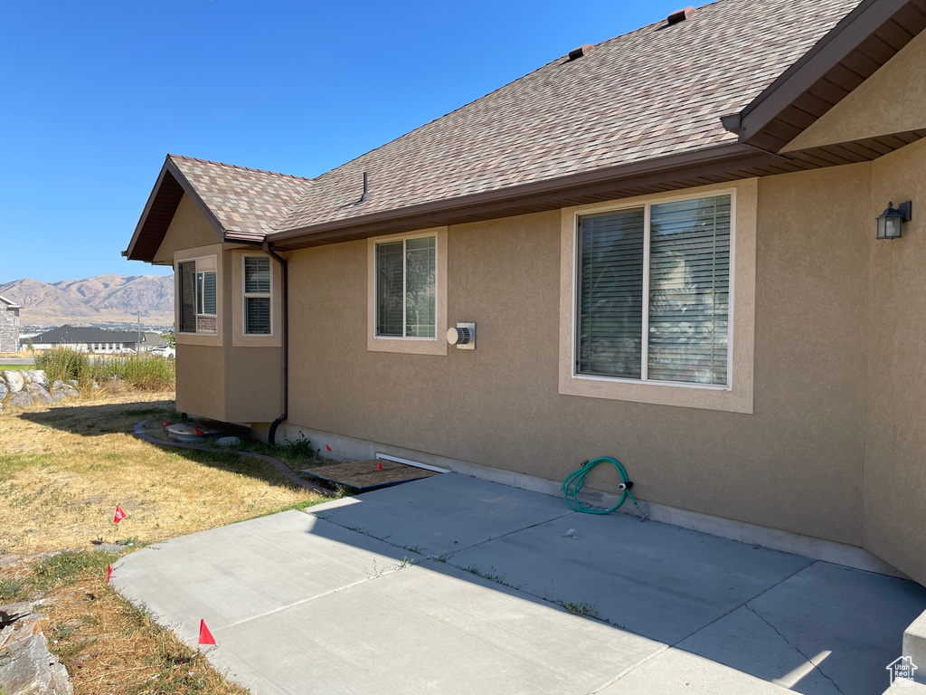 View of property exterior featuring a mountain view, a yard, and a patio area