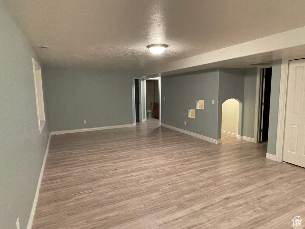 Empty room featuring a textured ceiling and light hardwood / wood-style flooring