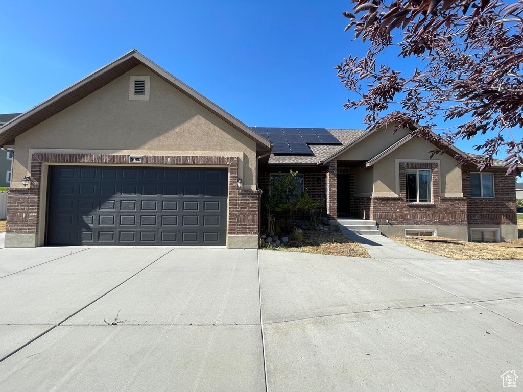 View of front of house featuring a garage and solar panels