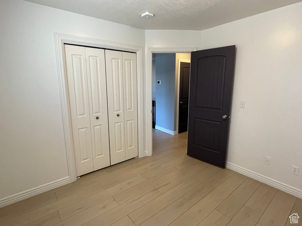 Unfurnished bedroom featuring a closet and light hardwood / wood-style floors