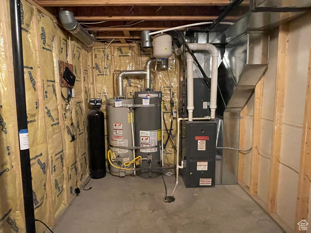 Utility room featuring gas water heater and water heater