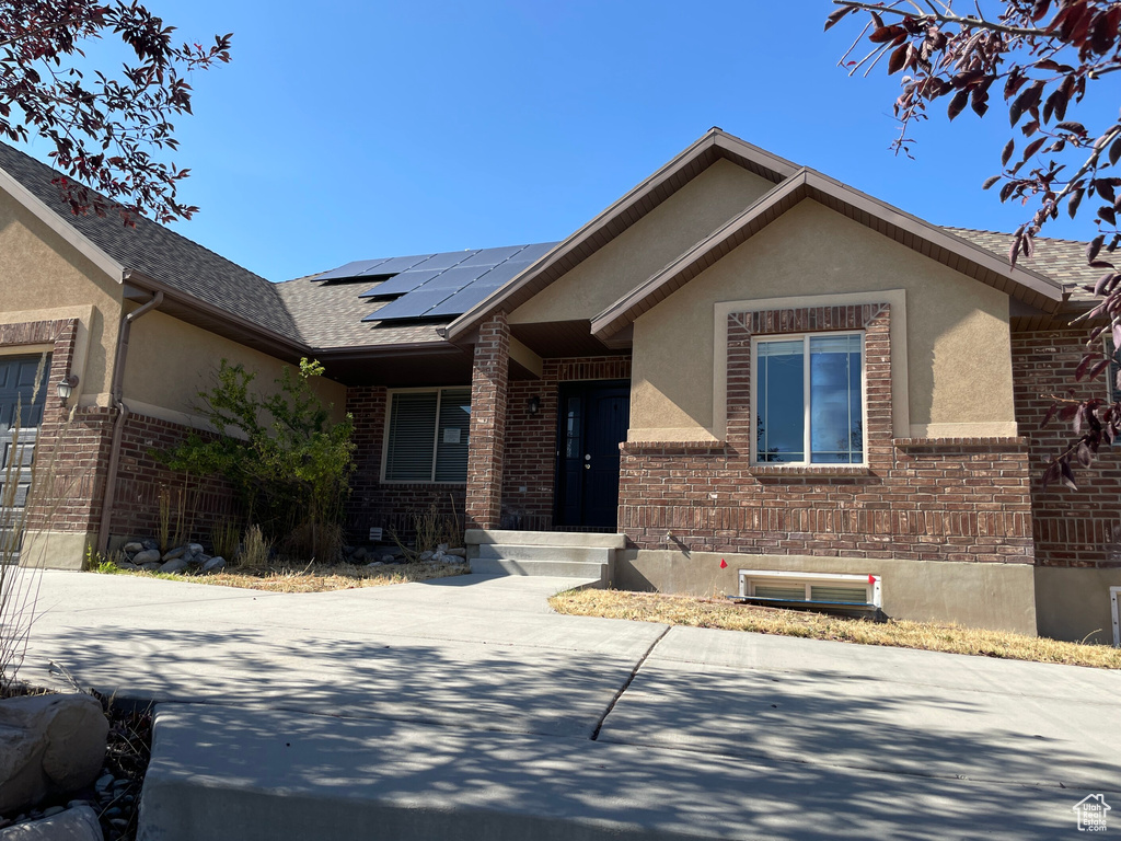 Ranch-style home featuring solar panels