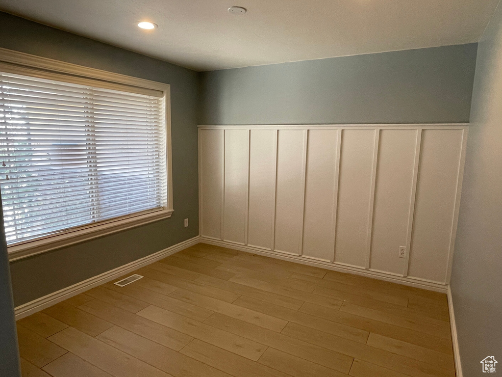 Empty room featuring a wealth of natural light and light wood-type flooring