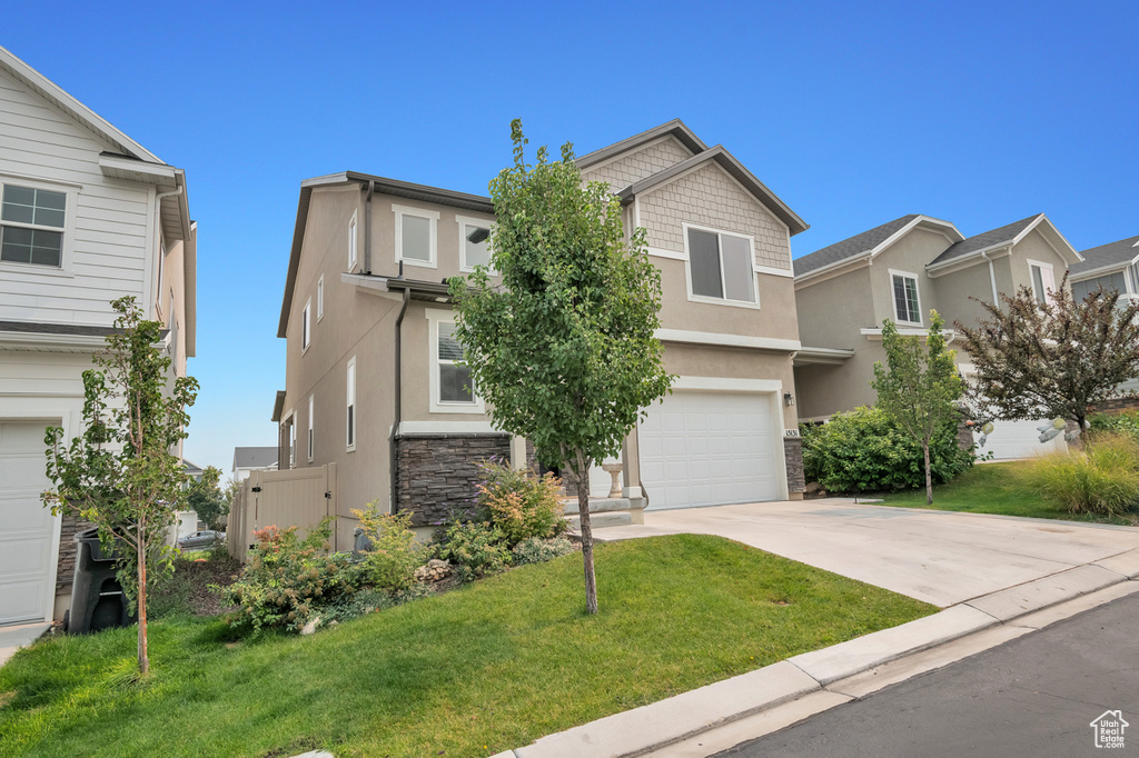 View of front of home with a garage and a front lawn