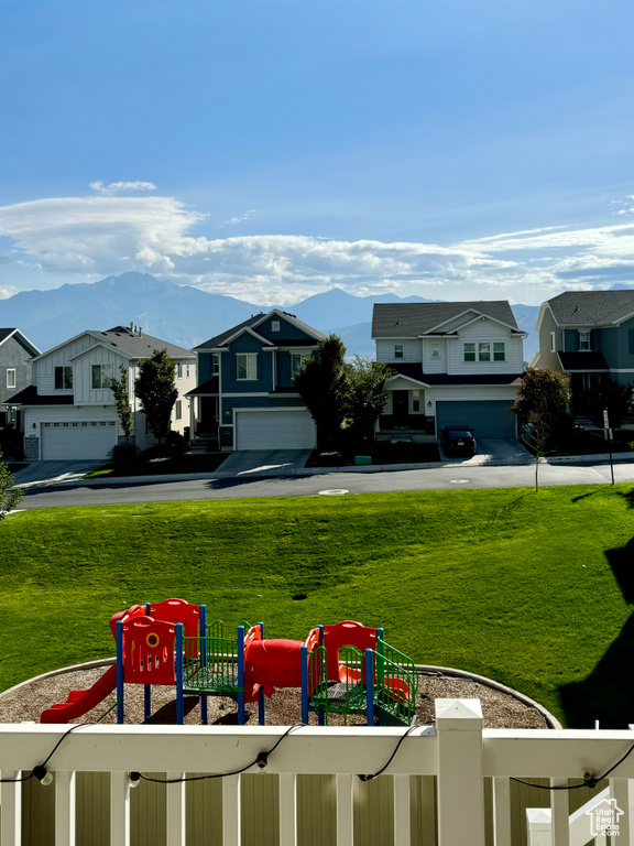 View of yard with a playground, a mountain view, and a garage