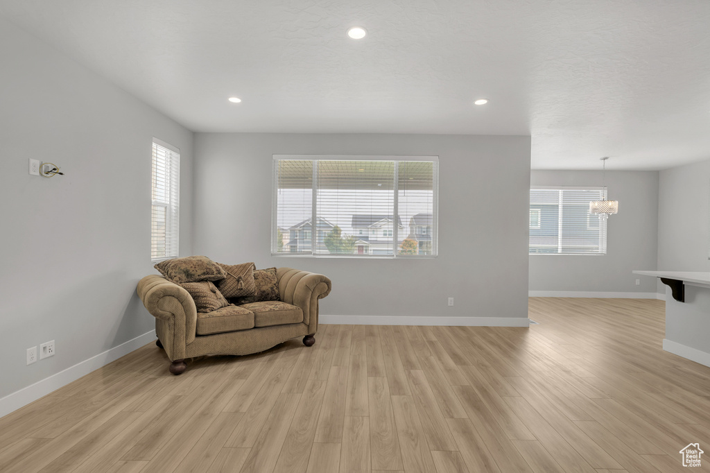 Sitting room featuring light wood-type flooring, plenty of natural light, and a chandelier