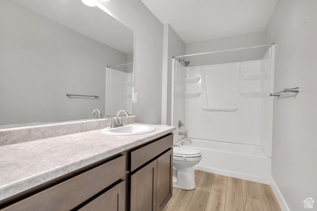 Full bathroom featuring vanity, toilet, shower / tub combination, and hardwood / wood-style flooring