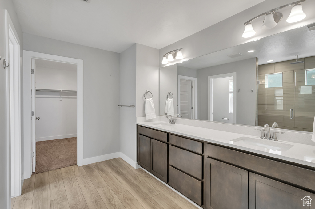 Bathroom with hardwood / wood-style floors, an enclosed shower, and vanity