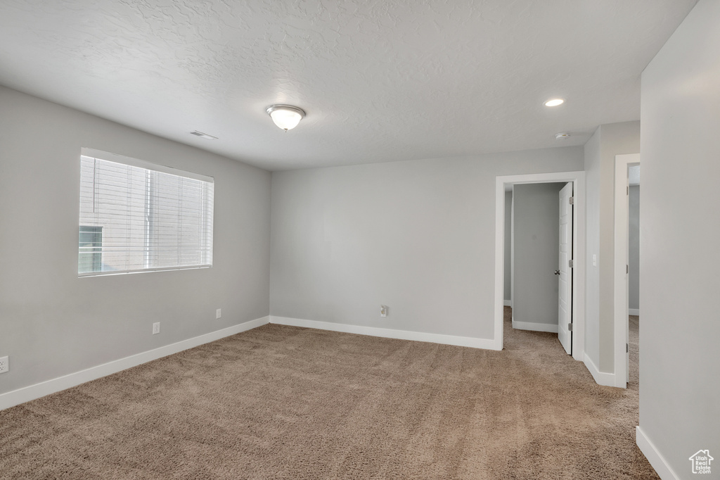 Empty room with a textured ceiling and carpet