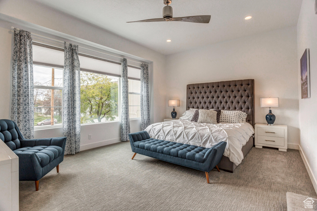 Carpeted bedroom featuring ceiling fan