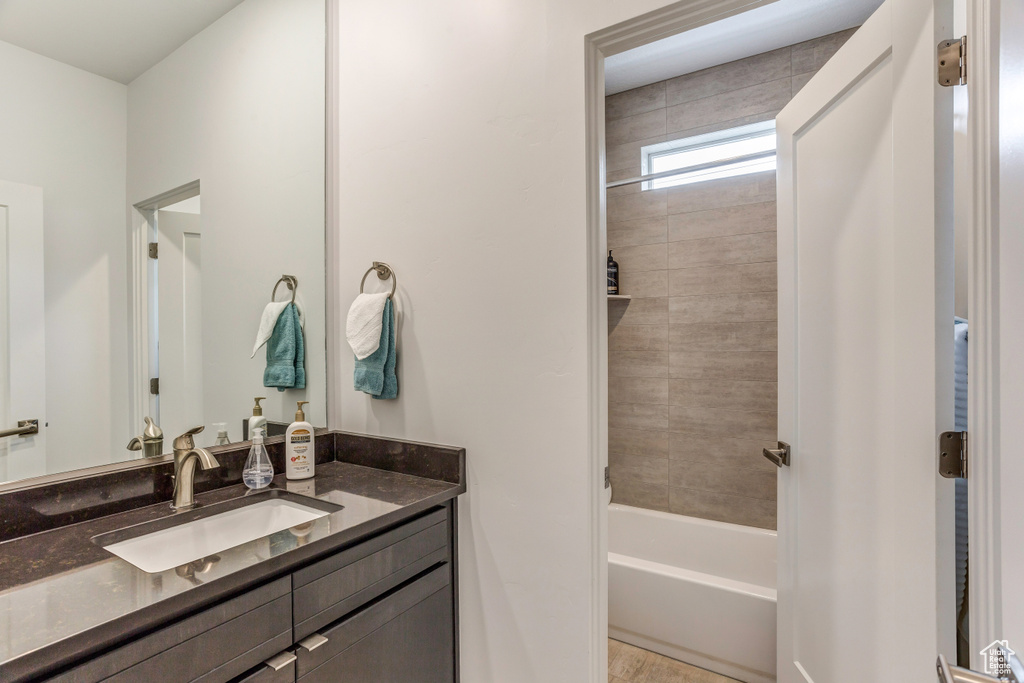 Bathroom featuring tiled shower / bath and vanity