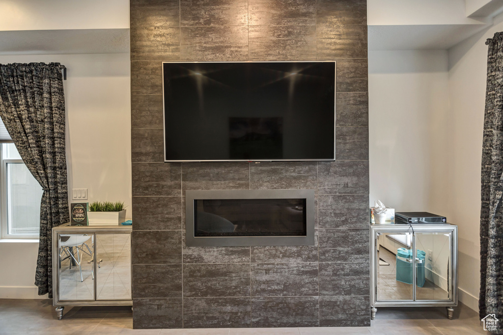 Room details featuring concrete floors and a tile fireplace