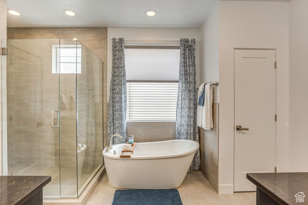 Bathroom with tile patterned floors, shower with separate bathtub, and vanity