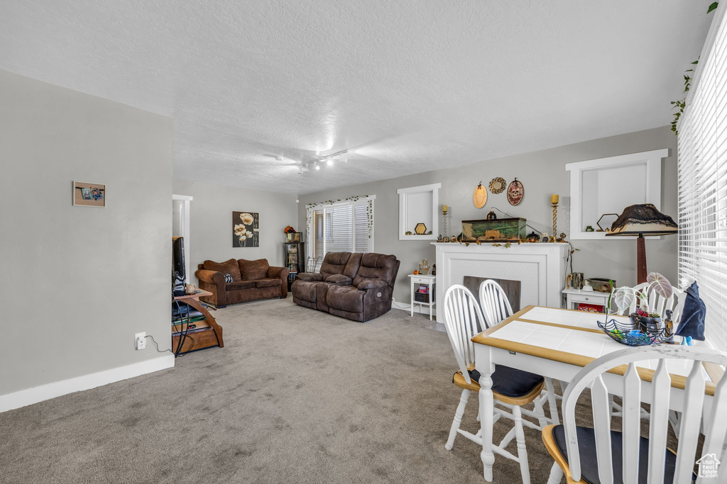 Dining space featuring a textured ceiling, carpet, and ceiling fan